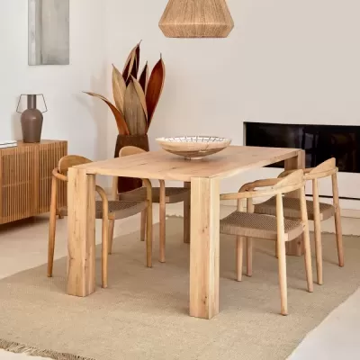 Mesa de jantar em madeira clara com cadeiras e decoração interior