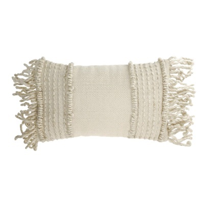 Almofada retangular creme com textura tecida e franjas nas extremidades