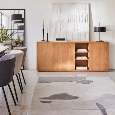 Móvel de madeira carvalho com decoração minimalista e tapete cinza com formas geométricas