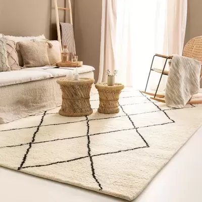 Tapete branco com padrão geométrico preto numa sala de estar com sofá e cadeiras