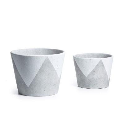 Dois vasos de cimento cinza com padrão geométrico em branco, sobre fundo branco