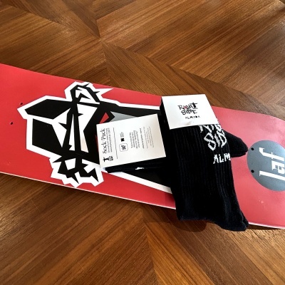 Skate vermelho com grafismo preto e branco e meia preta com texto com etiquetas