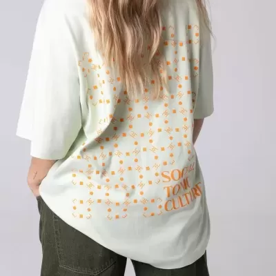 T-shirt verde claro com estampa laranja nas costas e calças largas verdes escuras