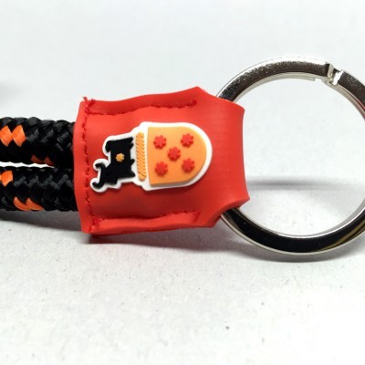 Porta-chaves com argola metálica e cordão preto e laranja e aplique de silicone vermelho com caneca de cerveja