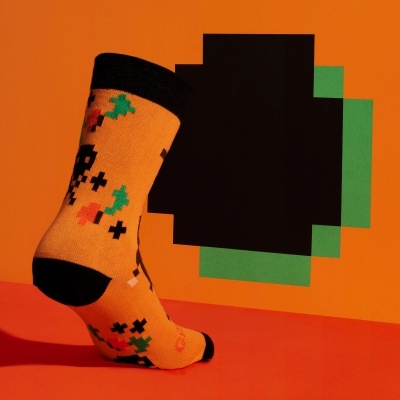 Meia colorida com padrão pixelado em tons laranja e preto