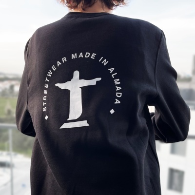 Sweat preta com estampa branca do Cristo Redentor e texto STREETWEAR MADE IN ALMADA nas costas