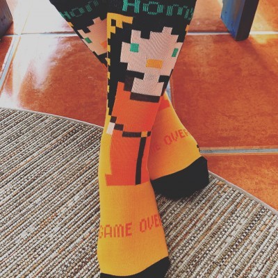 Meias coloridas com padrão pixelizado e texto GAME OVER