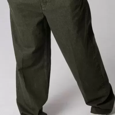 Calças largas verdes com bolsos frontais e sapatos de salto branco.