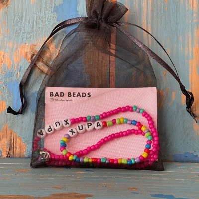 Colar de contas coloridas com letras em embalagem transparente preta