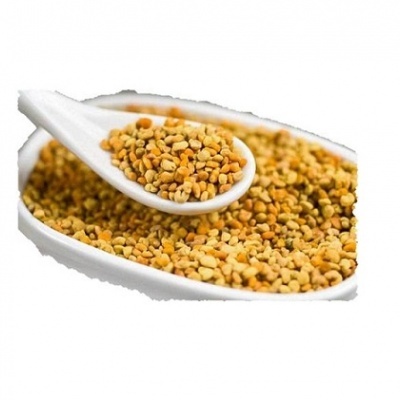 Pólen de abelha amarelo e laranja numa colher e num prato branco