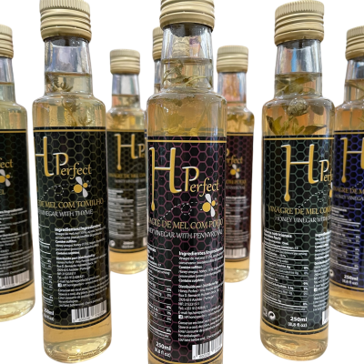 Garrafas de vidro com líquido dourado e rótulos pretos, tampas douradas