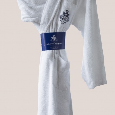 Robe de banho branco com bordado e etiqueta azul pendurado num cabide