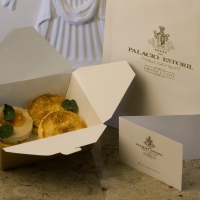 Doces numa caixa branca com saco e cartão do Palácio Estoril.