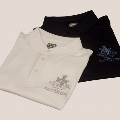 Duas polos dobradas, branca e preta, com bordados e botão de abotoar