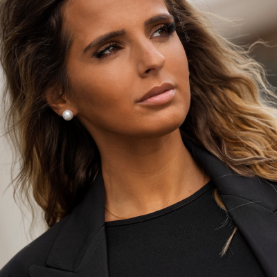 Mulher com brincos de pérola e roupa preta