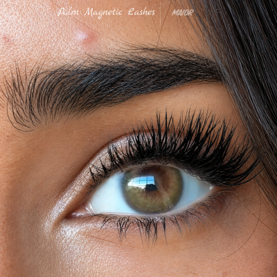 Close-up de olho com pestanas postiços volumosos e sobrancelha escura com texto próximo