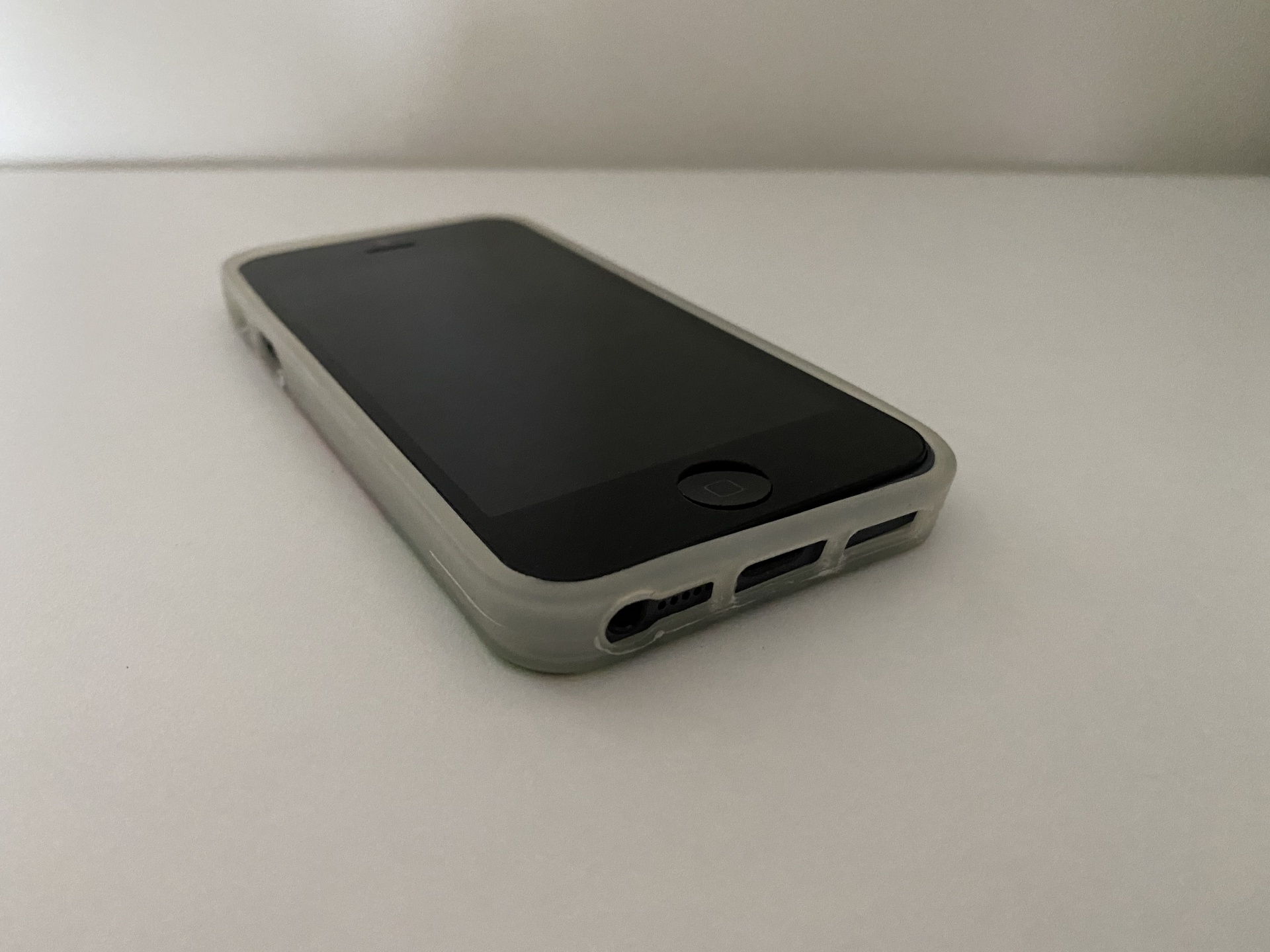 iPhone 5/5S/SE Capa Silicone Watermelon Smartphone preto com capa branca sobre superfície branca