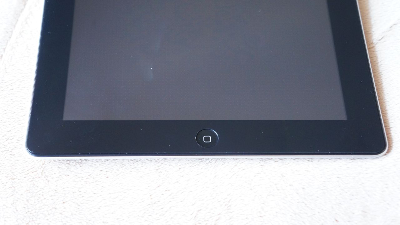 Película PET (plástica) de Protecção de Ecrã 100% Transparente para iPad Tablet preto com botão circular em fundo de tecido claro