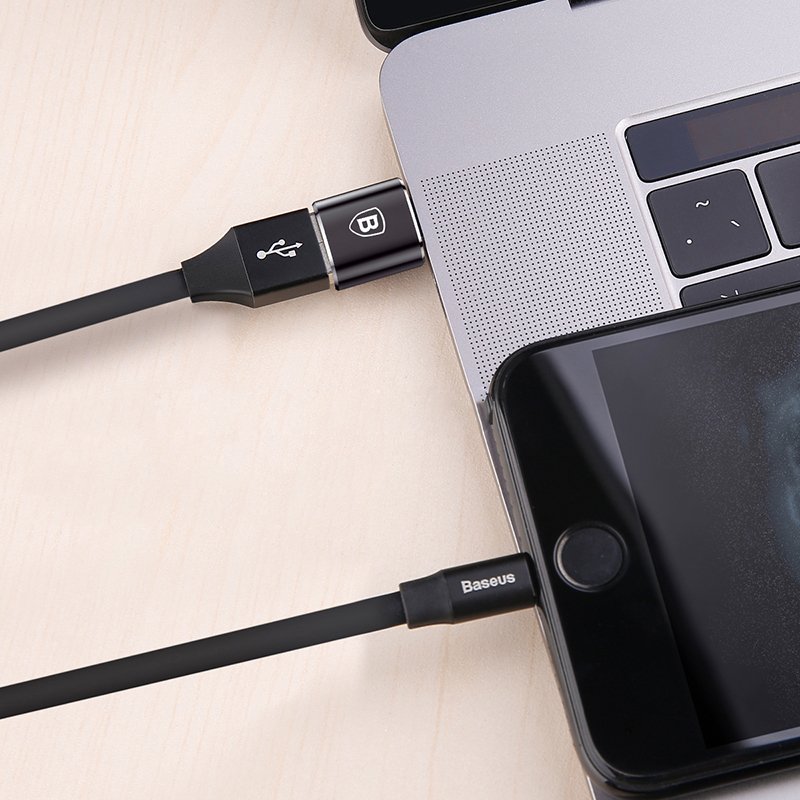 Adaptador USB para USB-C (OTG) Cabo USB preto Baseus ligado a computador portátil e smartphone sobre mesa de madeira