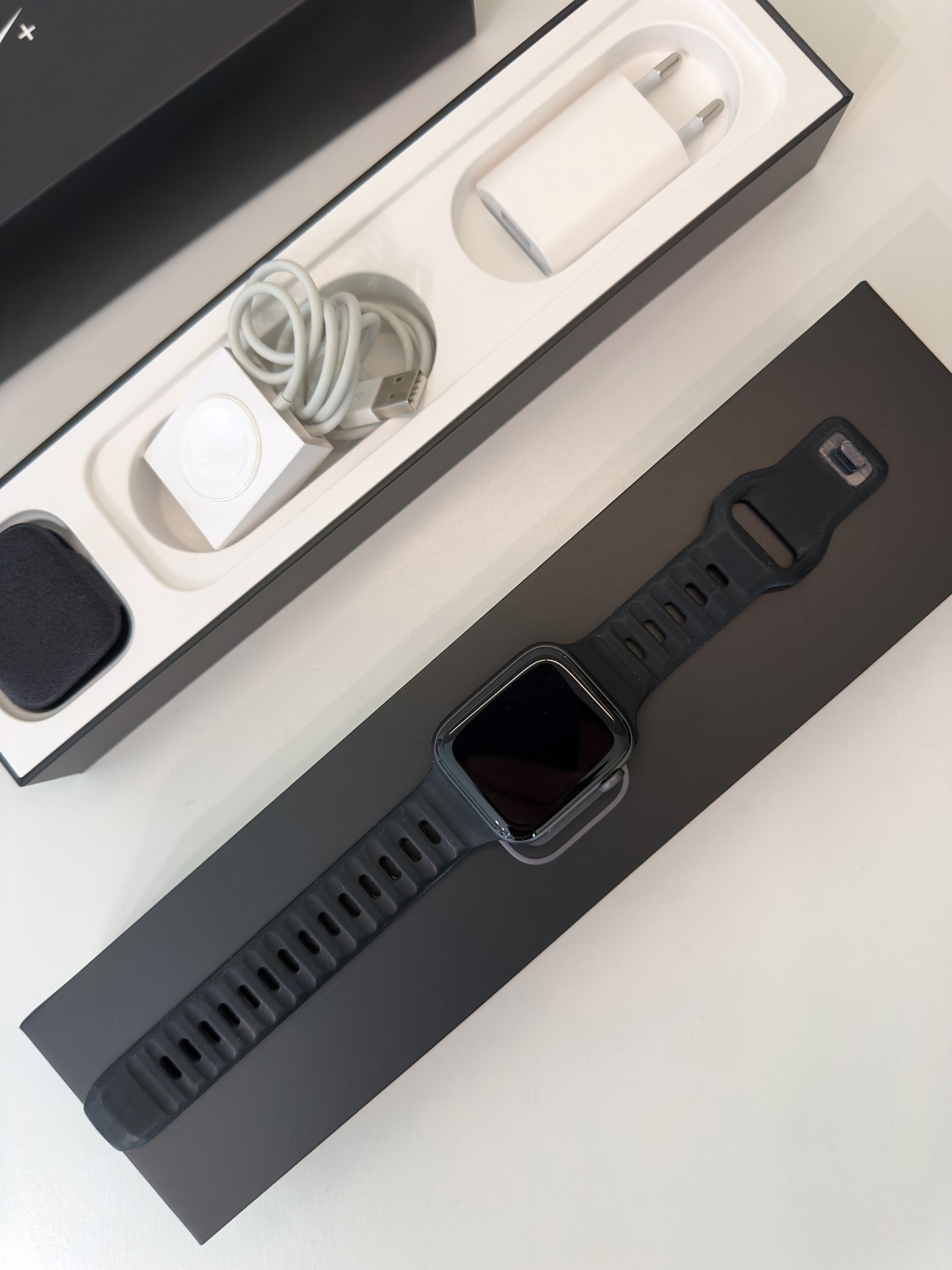 Apple Watch Series 4 Nike+ GPS Space Gray 44mm (de Ocasião) Relógio inteligente preto com acessórios de carregamento numa caixa