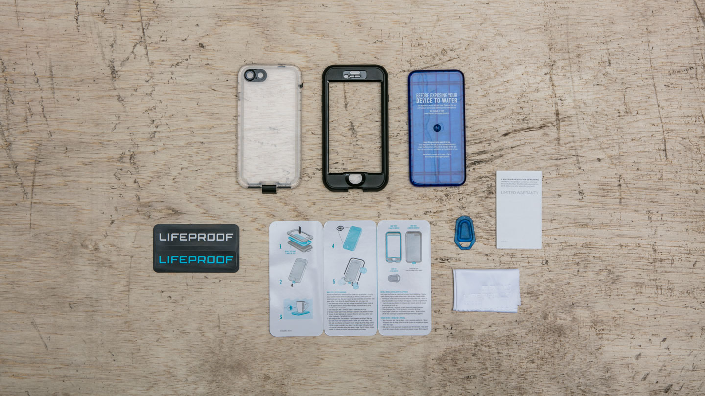 iPhone 7 Plus Capa Lifeproof NÜÜD Acessórios LifeProof para telemóvel com capa, moldura, manuais e autocolantes numa mesa de madeira