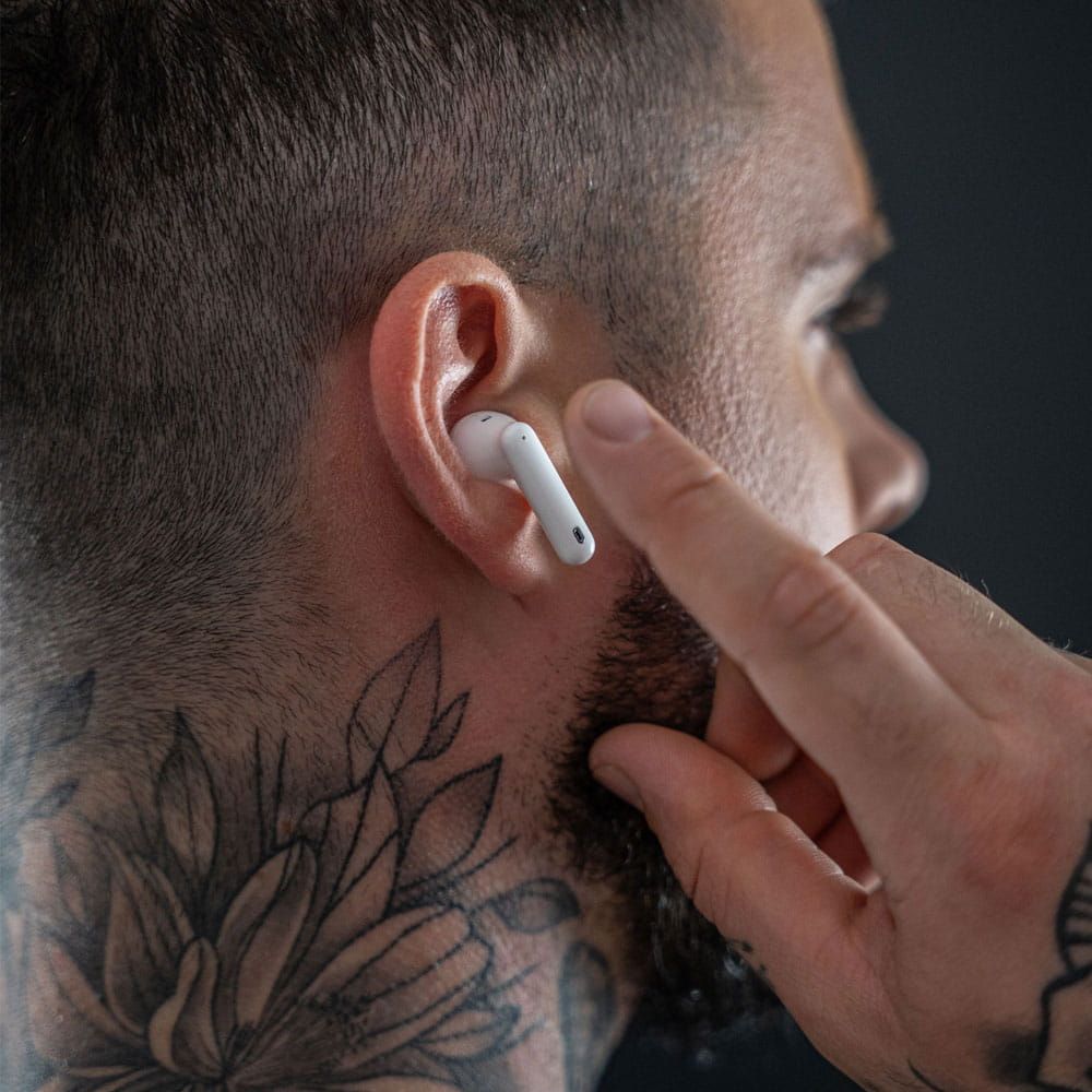 Auriculares 3mk Hardy LifePods Pro™ ANC - Branco Auricular branco sem fios no ouvido de homem com tatuagem e cabelo curto