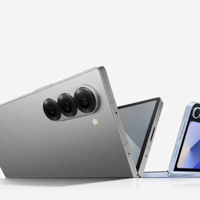 Tablet prateado com três câmaras e smartphone dobrável azul claro abertos