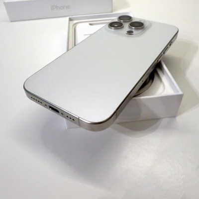 Smartphone iPhone prateado com três câmaras em caixa branca