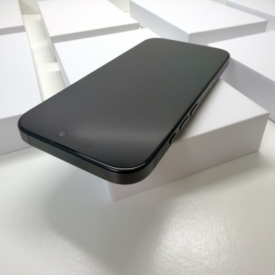 Smartphone preto com ecrã desligado sobre caixas brancas