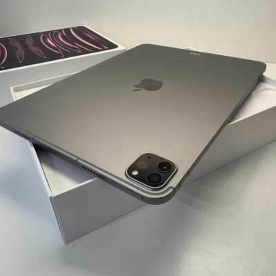 Tablet Apple iPad Pro cinzento espacial dentro de caixa branca com tampa ao lado