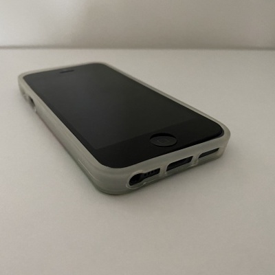 Smartphone preto com capa branca sobre superfície branca