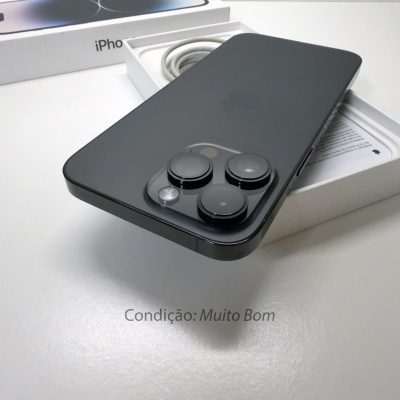 iPhone preto com três câmaras na traseira sobre caixa aberta branca incluindo cabo branco