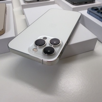 Smartphones iPhone variados em branco, preto e dourado sobre caixas brancas