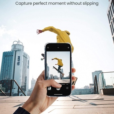 Telefone com capa preta numa mão a fotografar um skatista com casaco amarelo em cidade urbana