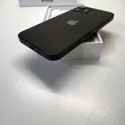 iPhone preto com três câmaras a sair da caixa branca com texto 'iPhone' na tampa