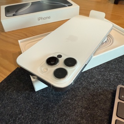 Smartphone iPhone branco com três câmaras na parte traseira sobre caixa aberta