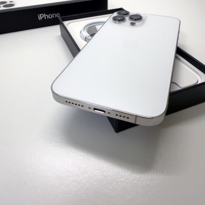 Smartphone branco Apple iPhone com três câmaras em cima da caixa.