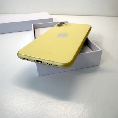 Smartphone Apple iPhone amarelo colocado parcialmente dentro de caixa branca