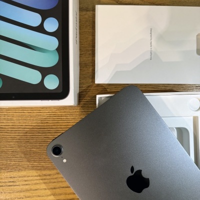 Tablet Apple iPad cinza espacial com embalagem em fundo de madeira