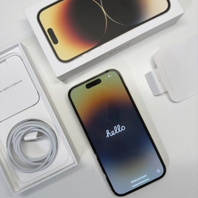 iPhone com ecrã ligado em cima de mesa com caixa e acessórios