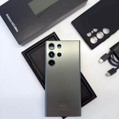 Smartphone Galaxy S23 Ultra verde com capa preta, caixa e cabo USB-C em fundo branco