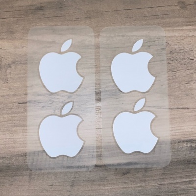 Adesivos transparentes com logotipo branco da Apple em superfície de madeira clara