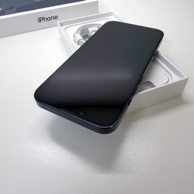 Smartphone preto sobre caixa branca com cabo branco e caixa exterior iPhone