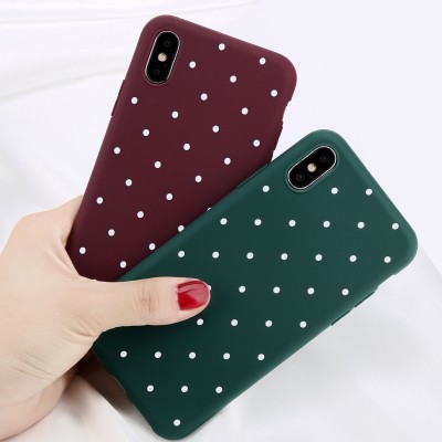 Duas capas de telemóvel verdes e vinho com bolinhas brancas.