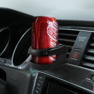Lata de Coca-Cola vermelha num suporte de copos preto em carro junto a botão PASSENGER AIR BAG