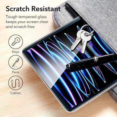 Tablet com vidro temperado resistente a riscos, caneta preta, três chaves e saco cinza sobre mesa de madeira