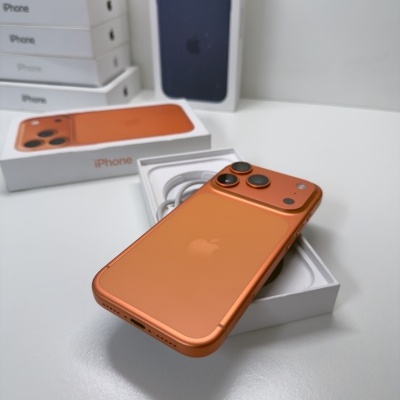 iPhone laranja com três câmaras sobre caixa branca com texto iPhone