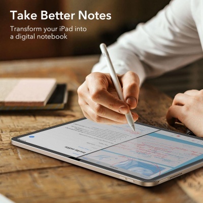 Pessoa a escrever num iPad com caneta digital sobre mesa de madeira