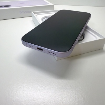Smartphone iPhone lilás com ecrã preto dentro da caixa branca com texto iPhone