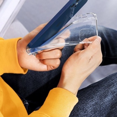 Capa transparente de silicone para smartphone azul nas mãos de uma pessoa com casaco amarelo.